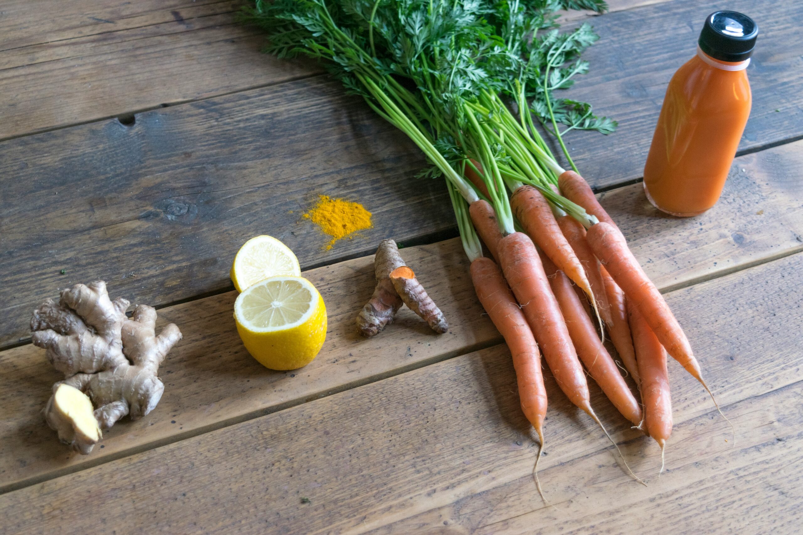 carrot and green vegetable on brown wooden table