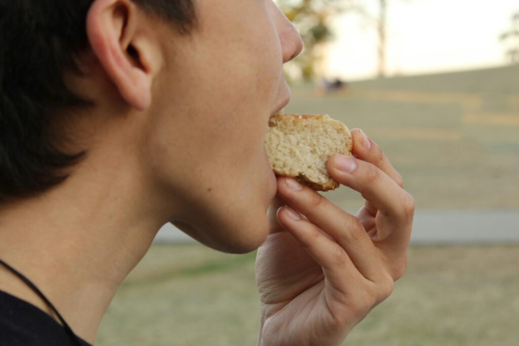 A woman eating a sandwich in a park